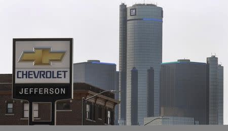 The sign to a Chevrolet automobile dealership is seen down the street from General Motors World Headquarters on Jefferson Avenue in Detroit, Michigan April 2, 2014. REUTERS/Rebecca Cook