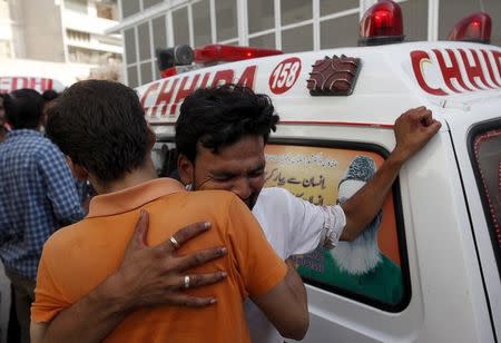 Relatives mourn the death of men, who were killed by unidentified gunmen, outside a hospital morgue in Karachi, Pakistan, September 9, 2015. REUTERS/Akhtar Soomro