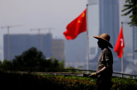 FILE PHOTO: A gardener waters plants at a park near the City Hall in Hong Kong