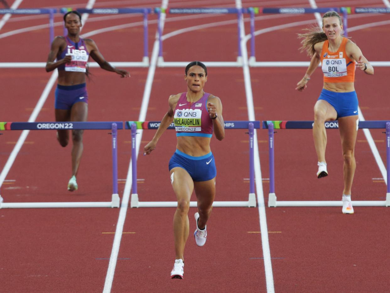 USA's Sydney McLaughlin, center, races to the finish in the women's 400 meter hurdles on her way to a world record during day eight of the World Athletics Championships at Hayward Field in Eugene, Oregon Friday July 22, 2022.