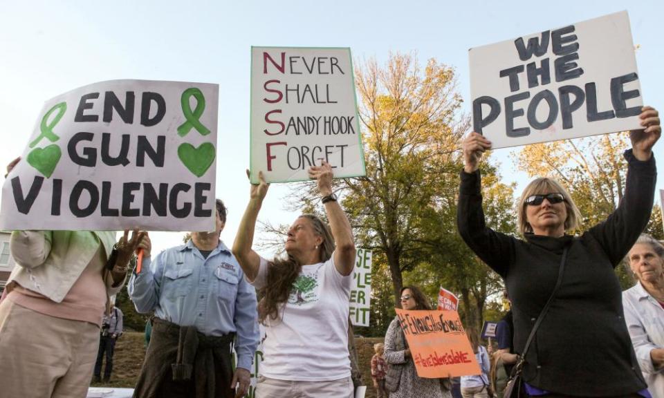 Mourners hold signs during a solidarity vigil in memory of victims of the Las Vegas shooting, in Newtown, Connecticut. 