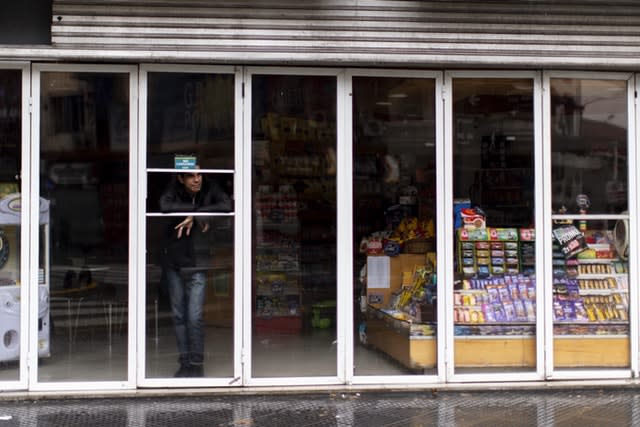 A man stands inside a shop without power 