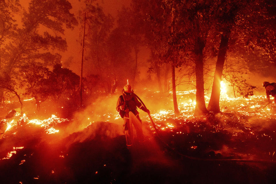 ARCHIVO – En esta fotografía del 7 de septiembre de 2020, bomberos combaten el incendio Creek que amenaza diversas casas en el vecindario de Cascadel Woods, en el condado Madera, en California. (AP Foto/Noah Berger, Archivo)