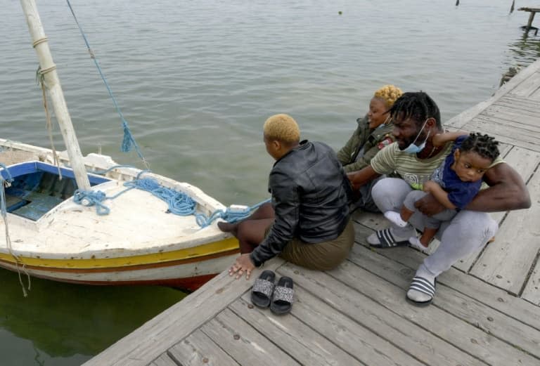 Des migrants africains devant un bateau de pêche dans la ville côtière de Sfax en Tunisie, le 22 avril 2021 - FETHI BELAID © 2019 AFP