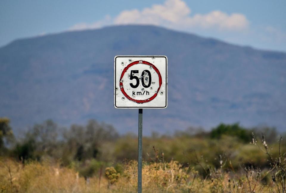 A speed limit sign is seen with bullet holes on the Buenavista Tomatlan - Aguililla highway,