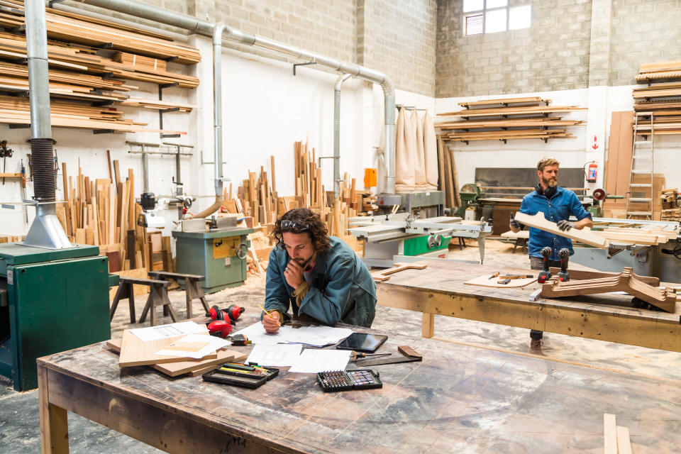 Workers in a small light industrial furniture factory specialising in wood joinery and carpentry