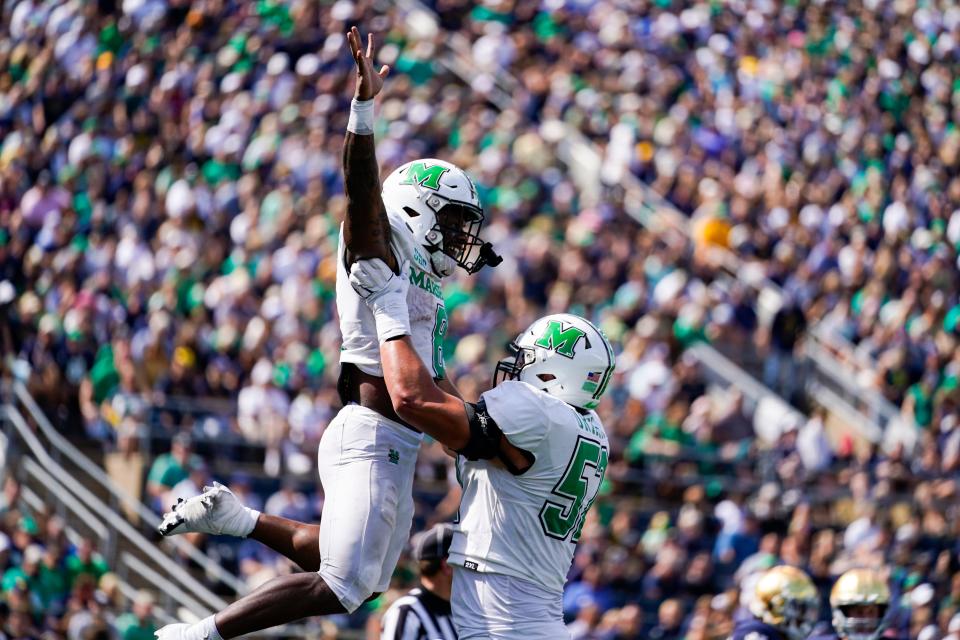 Marshall offensive lineman Ethan Driskell (52) lifts up wide receiver Cam Pedro (80) as they celebrate a touchdown against Notre Dame on Sept. 10, 2022 in  South Bend, Indiana. Marshall upset Notre Dame, then lost 34-31 in overtime the next Saturday to Bowling Green.