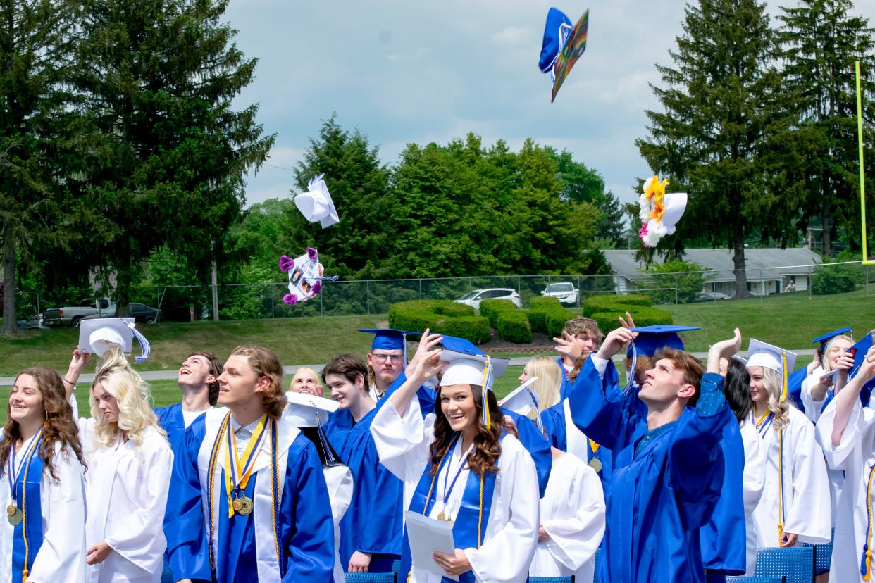 Graduates toss their caps in the air as the class of 2021 from Cambridge High School.