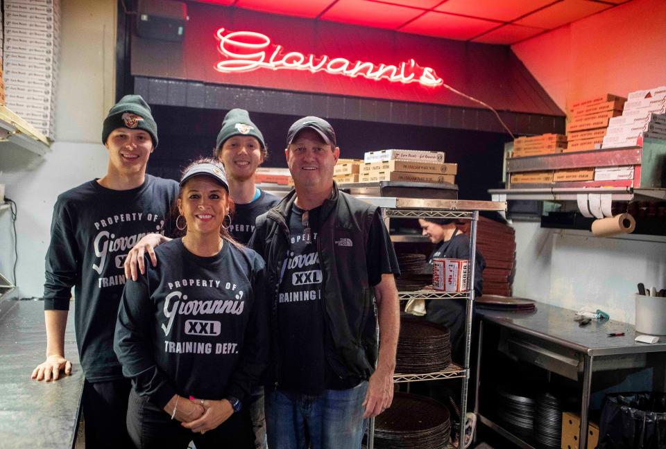 Mike and Leslie Payne and sons Cameron Logan Snowden stand in the kitchen of Giovanni's Pizza on November 15, 2022 in Chillicothe, Ohio.