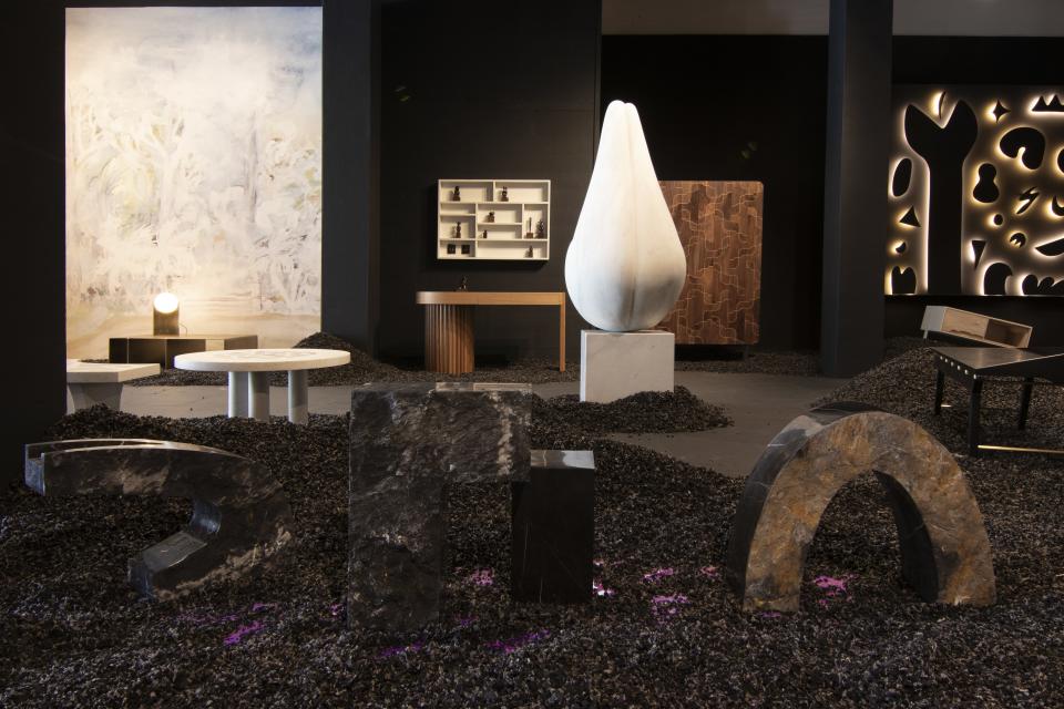A selection of side tables by A Space in front of a sculpture by Dorian Goldman, wood desk by Kate Duncan, and white table and chairs by Robert Sukrachand.