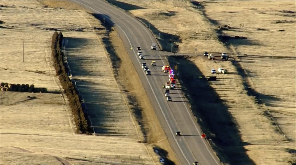 Emergency responders investigate the scene of a crash, Thursday, Feb. 22, 2024 on U.S. 287 about 10 miles (16 kilometers) south of the Wyoming-Colorado line between Laramie and Fort Collins, Colo. Three members of the University of Wyoming swimming and diving team were killed in the crash. (KMGH Denver7 via AP)