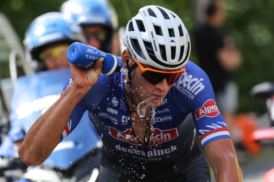 Alpecin-Deceuninck's Dutch rider Mathieu Van Der Poel sprays himself with water to cool down as he cycles in a breakaway in the ascent of the Col de la Croix Montmain during the 12th stage of the 110th edition of the Tour de France cycling race, 169 km between Roanne and Belleville-en-Beaujolais, in central-eastern France, on July 13, 2023. (Photo by Thomas SAMSON / AFP)