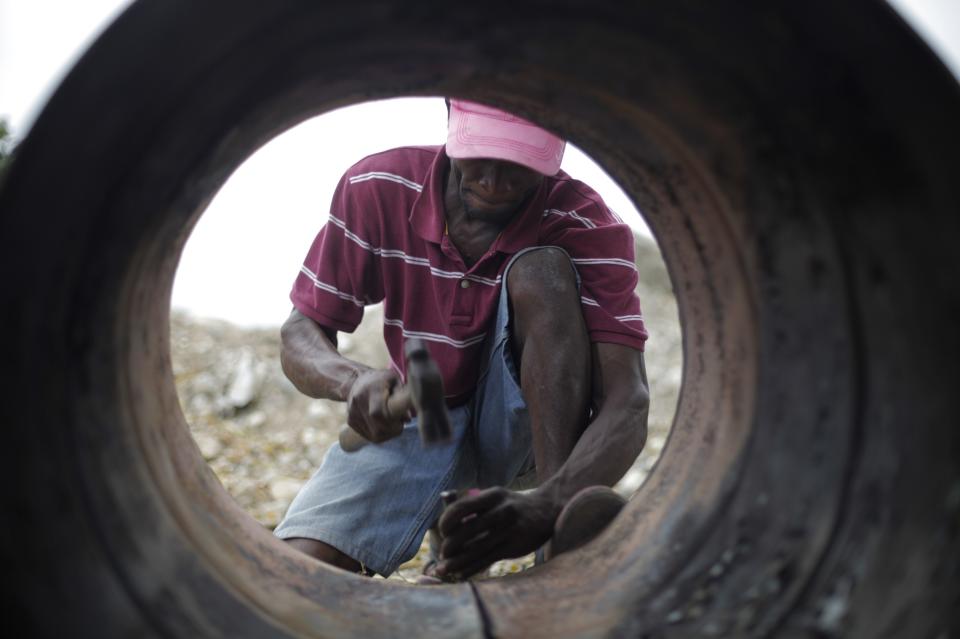 Sony Lonrisme corta un barril de petróleo en Noailles, un pueblo de artesanos en Puerto Príncipe.