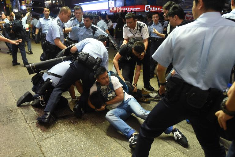 Police arrest a protester as they try to clear a road at a pro-democracy protest site in the Mongkok district of Hong Kong, on November 25, 2014