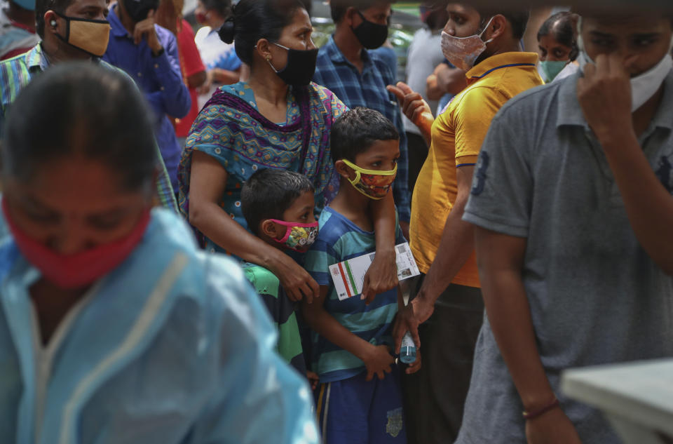 FILE - In this April 25, 2021, file photo, people wearing masks as a precaution against the coronavirus wait to test for COVID-19 at a government hospital in Hyderabad, India. The World Health Organization said Monday, May 10, that a worrisome variant was first detected in India may spread more easily. Scientists are still trying to figure out if it resulted in the terrifying surge of infections in the nation, and looking to see if this could this happen elsewhere. (AP Photo/Mahesh Kumar A.)