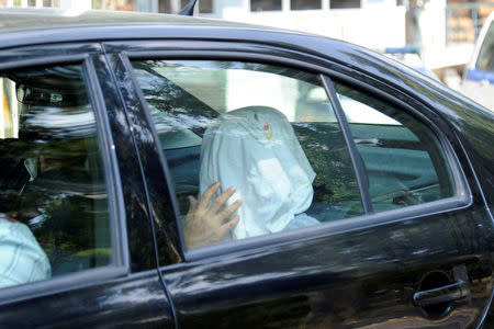One of the eight Turkish soldiers, who fled to Greece in a helicopter and requested political asylum after a failed military coup against the government, is seen in a police car with his face covered, after his interview for asylum request at the Asylum Service in Athens, Greece, August 22, 2016. REUTERS/Michalis Karagiannis/File Photo