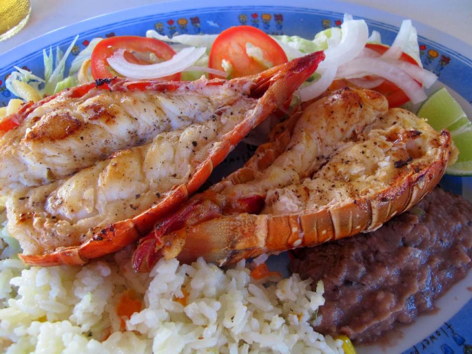 This November 2012 photo shows fresh grilled lobster at a popular lunch spot known as Velasquez Restaurant after just being caught in the sea off Isla Mujeres, Mexico. Isla Mujeres, or Island of Women, is a tiny 5-mile-long, half-mile wide island just a half-hour's ferry ride across from Cancun, with far fewer visitors and a much calmer, romantic atmosphere. (AP Photo/Amanda Lee Myers)