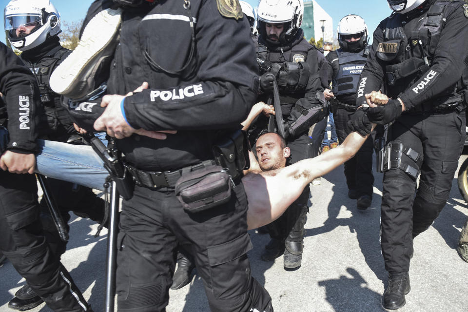 Police detain a protester at the University of Thessaloniki in northern Greece, on Monday, Feb. 22, 2021. Police clashed with protesters and detained more than 30 people in Greece's second-largest city Monday during a demonstration against a new campus security law. (AP Photo/Giannis Papanikos)