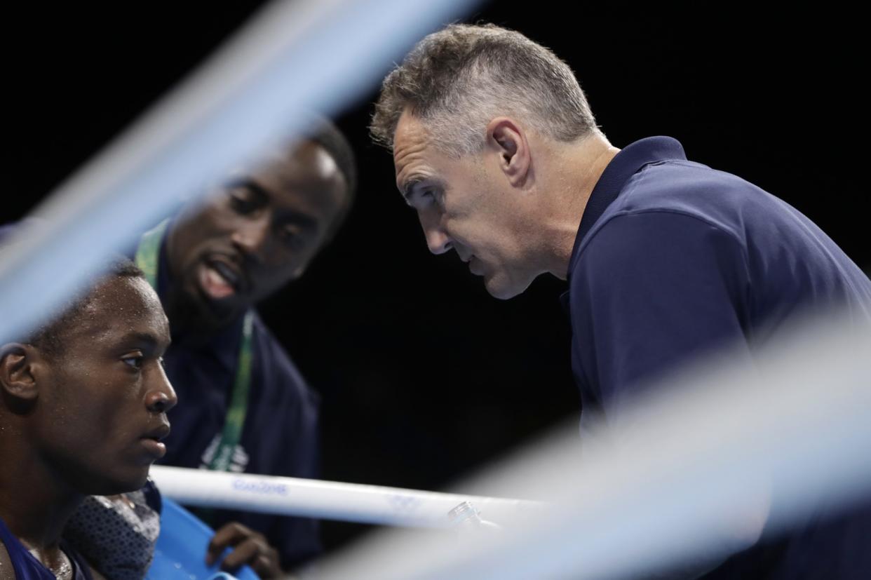 U.S. coach Billy Walsh (right) and trainer Kay Charles talk to boxer Albert Conwell. (AP)