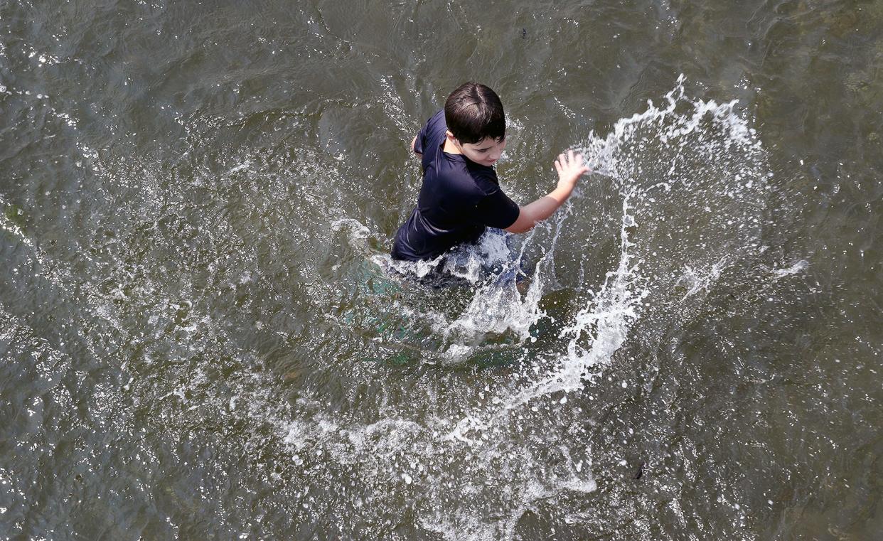 A child splashes in water at Silverdale Waterfront in August 2018. Forecasters are warning people to be careful about entering the water during this weekend's forecasted warm temperatures, saying that area rivers and lakes will remain cool.