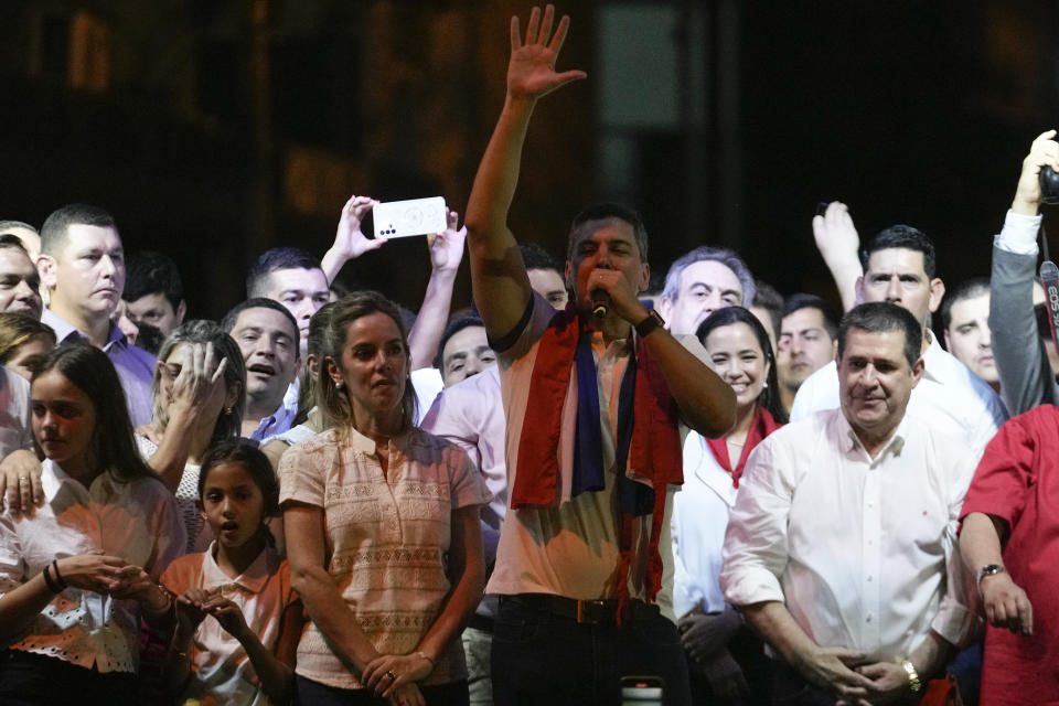 Santiago Peña, presidential candidate of the Colorado ruling party, center, talks beside former President Horacio Cartes, right, and his wife Leticia Ocampos after the voting closed during general elections in Asuncion, Paraguay, Sunday, April 30, 2023. (AP Photo/Jorge Saenz)