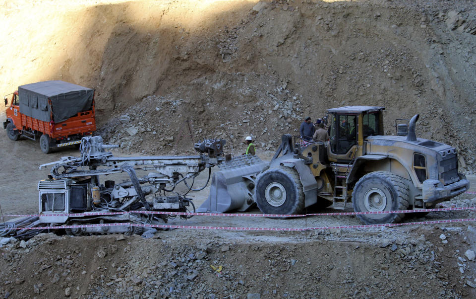 Heavy machinery stand near the entrance to the site of an under-construction road tunnel that collapsed in mountainous Uttarakhand state, India, Friday, Nov. 17, 2023. Rescuers drilled deeper into the rubble of a collapsed road tunnel in northern India on Friday to fix wide pipes for 40 workers trapped underground for a sixth day to crawl to their freedom. (AP Photo)