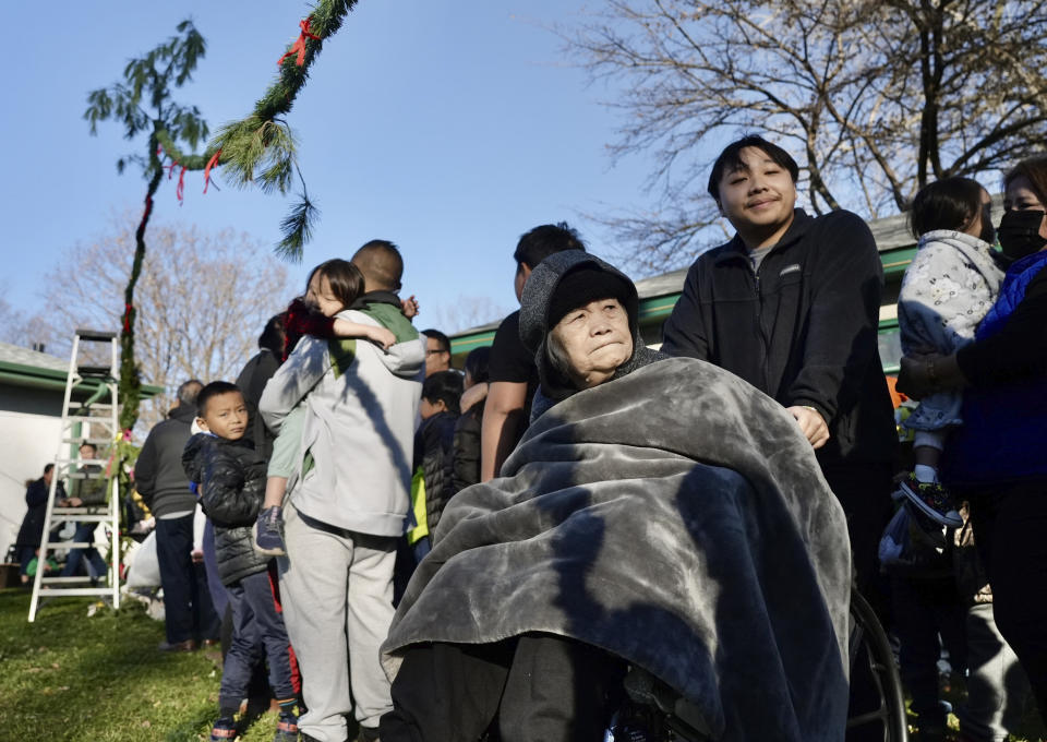 Family, friends and members of the Twin Cities Hmong community gather in the backyard of Nhia Neng Vang for a Hmong New Year sweeping ritual in St. Paul, Minn. on Saturday, Nov. 18, 2023. The ritual, in which participants walk together in circles, first to the west and then to the east, represents leaving old negative spirits behind and embracing the new year. (AP Photo/Mark Vancleave)