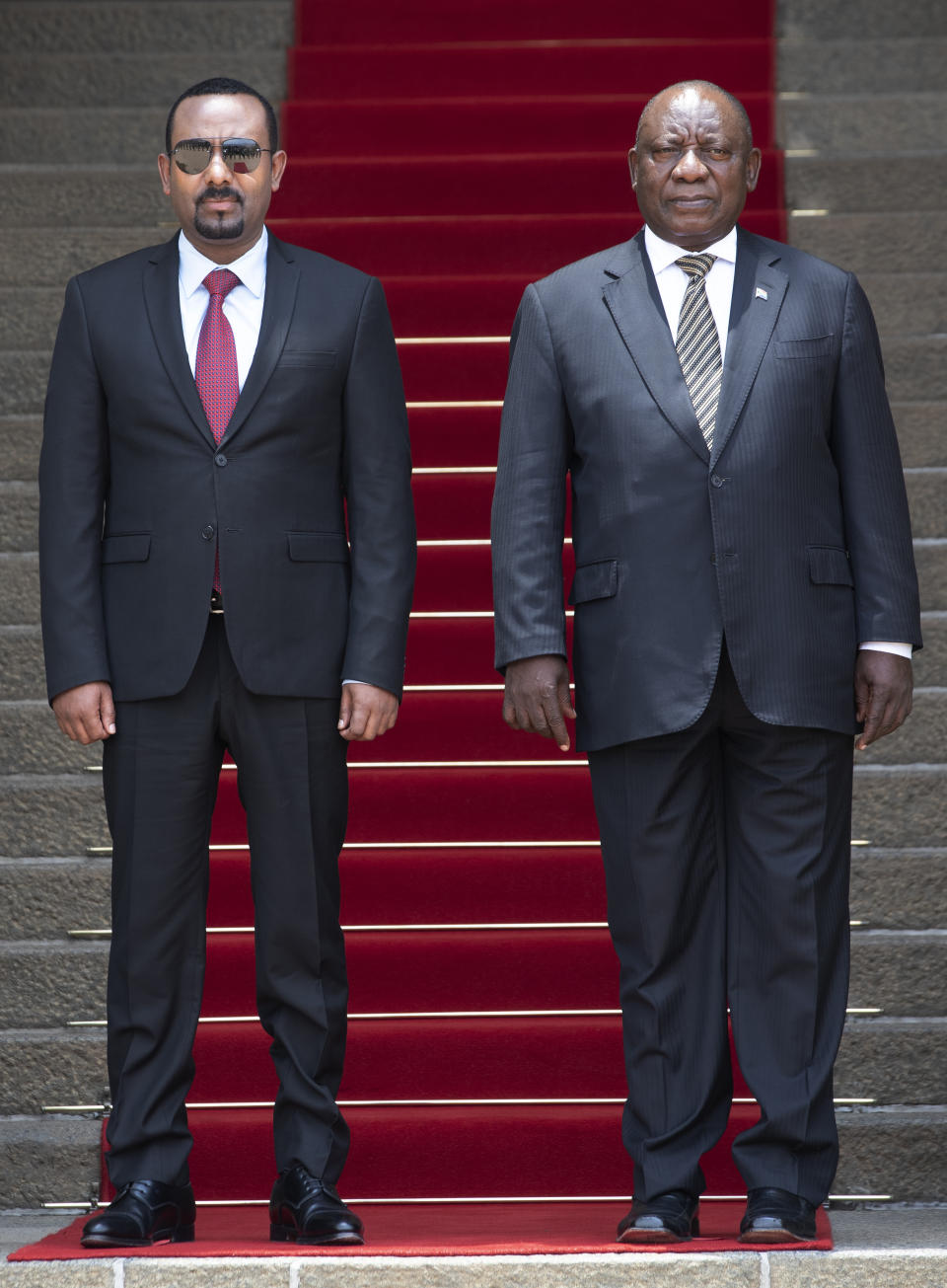 South African President Cyril Ramaphosa, right, with Ethiopia's Prime Minister Abiy Ahmed looks on during the singing of the national anthems by a guard of honor prior to their talks at the Union Building in Pretoria, South Africa, Sunday, Jan. 12, 2020. (AP Photo/Themba Hadebe)