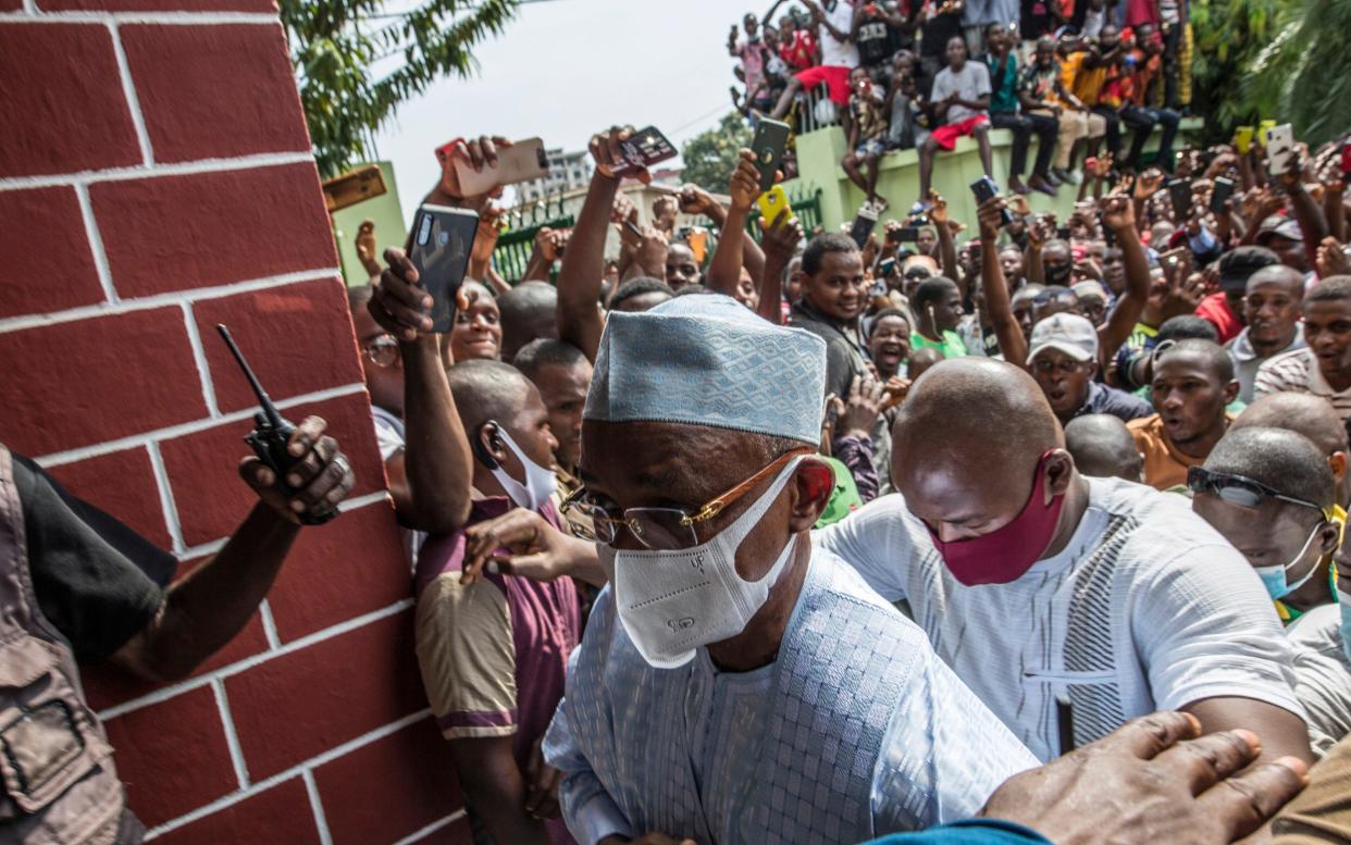 Guinean opposition leader Cellou Dalein Diallo walks past supporters - AP 