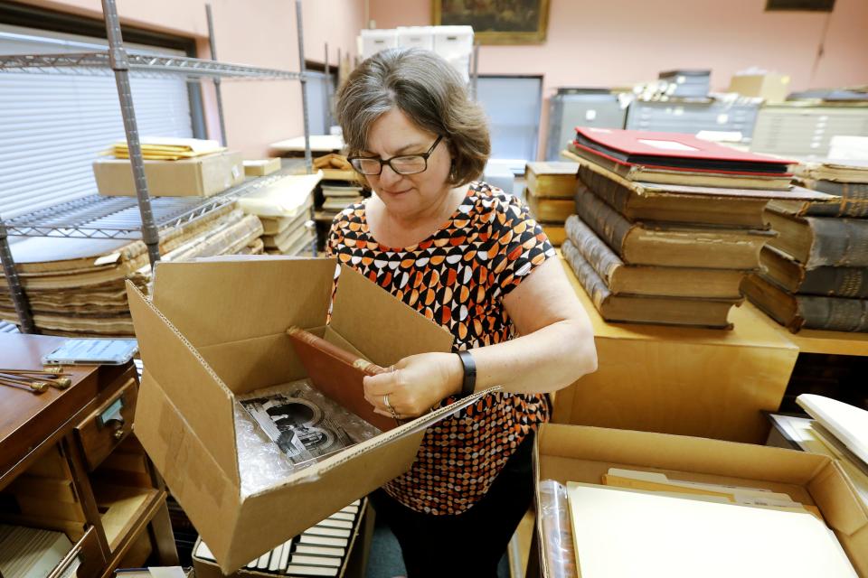 New Bedford Public Library Director, Olivia Melo, pulls the 100 year overdue book from the box shipped to New Bedford from West Virginia University Library on July 7, 2023. An Elementary Treatise on Electricity by James Clerk Maxwell was returned to the West Virginia University library one hundred years after it was taken out of the New Bedford Public library in 1903.