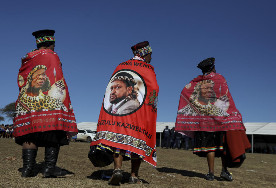 Women wear traditional dress, with cloth with the image of King Misuzulu ka Zwelithini, during his coronation, at KwaKhangelamankengane Royal Palace in Nongoma, South Africa. Saturday, Aug. 20, 2022. South Africa’s ethnic Zulu nation hosted a coronation event for its new traditional king amid internal divisions that have threatened to tear the royal family apart. King Misuzulu ka Zwelithini, a son of the late King Goodwill Zwelithini who died from a diabetes-related illness in March last year, will undergo the traditional ritual known as ukungena esibayeni (entering the royal village) to mark his installation as the new leader of the Zulu nation. (AP Photo)