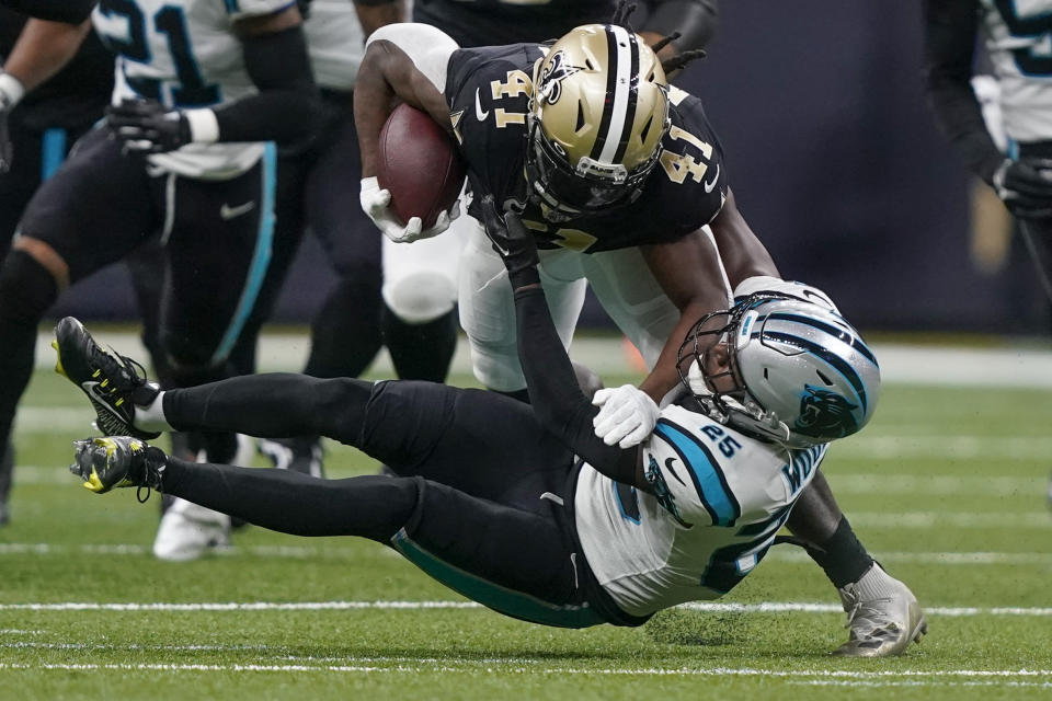 New Orleans Saints running back Alvin Kamara is tackled by Carolina Panthers safety Xavier Woods during the first half an NFL football game between the Carolina Panthers and the New Orleans Saints in New Orleans, Sunday, Jan. 8, 2023. (AP Photo/Gerald Herbert)