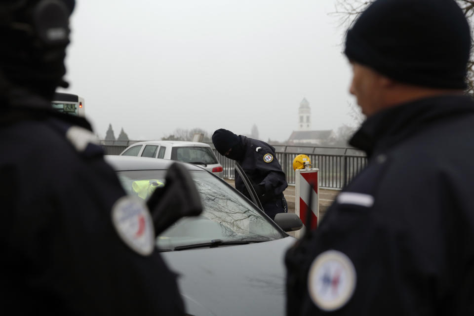 French police officers control a car at the French-German border following a shooting in Strasbourg, eastern France, Wednesday, Dec. 12, 2018. A man who had been flagged as a possible extremist sprayed gunfire near the city of Strasbourg's famous Christmas market Tuesday, killing three people, wounding 12 and sparking a massive manhunt. France immediately raised its terror alert level. (AP Photo/Christophe Ena)