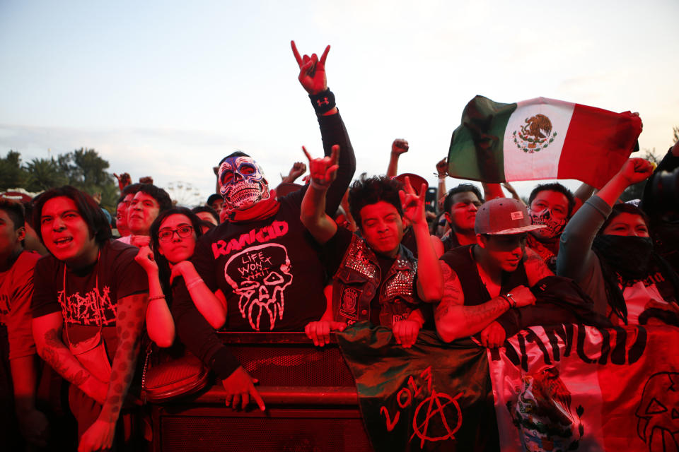 En esta imagen del 19 de marzo de 2017, aficionados bañados en luz roja jalean a la banda mexicana de metal Brujería durante el festival Vive Latino en Ciudad de México. El Festival Vive Latino se ha convertido en la mayor celebración en Latinoamérica del rock latino. (AP Foto/Rebecca Blackwell)