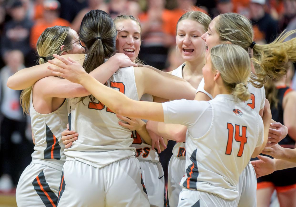 Annabelle Fortin, facing in the middle, and the Illini Bluffs Tigers celebrate their 60-48 overtime victory over Altamont in the Class 1A girls basketball state semifinal Thursday, Feb. 29, 2024 at CEFCU Arena in Normal.