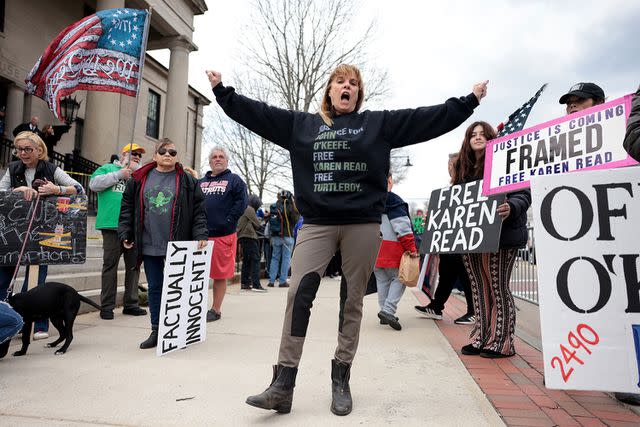<p>Jessica Rinaldi/The Boston Globe via Getty</p> A Karen Read supporter mugs for the camera before Read appeared in Norfolk Superior Court for a motions hearing.