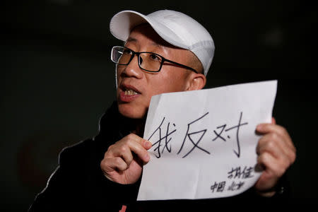 Chinese activist Hu Jia holds a paper as he speaks during an interview with Reuters in Beijing, China February 28, 2018. Picture taken February 28, 2018. The Chinese characters read, "I object". REUTERS/Thomas Peter