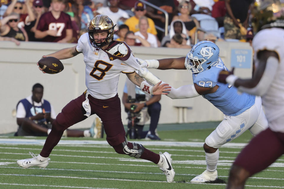 Minnesota quarterback Athan Kaliakmanis (8) is pulled down by North Carolina defensive lineman Jacolbe Cowan (93) during the second half of an NCAA college football game, Saturday, Sept. 16, 2023, in Chapel Hill, N.C. (AP Photo/Reinhold Matay)