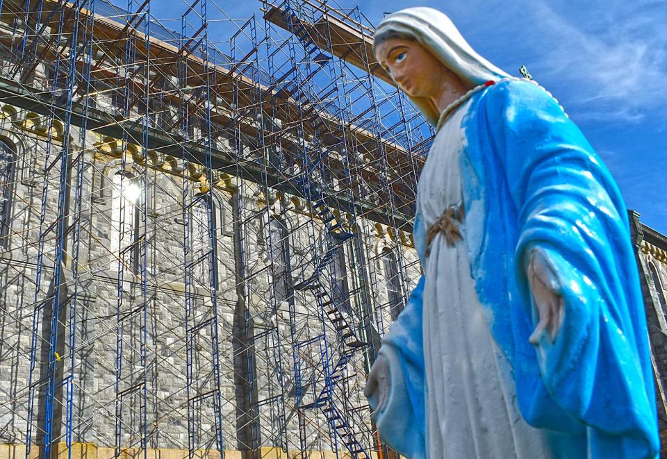 A statue of the Virgin Mary watches as scaffolding covers the Middle Street side of St. Anne's Church in Fall River on Friday, Nov. 17, 2023. The church is undergoing roof repairs.