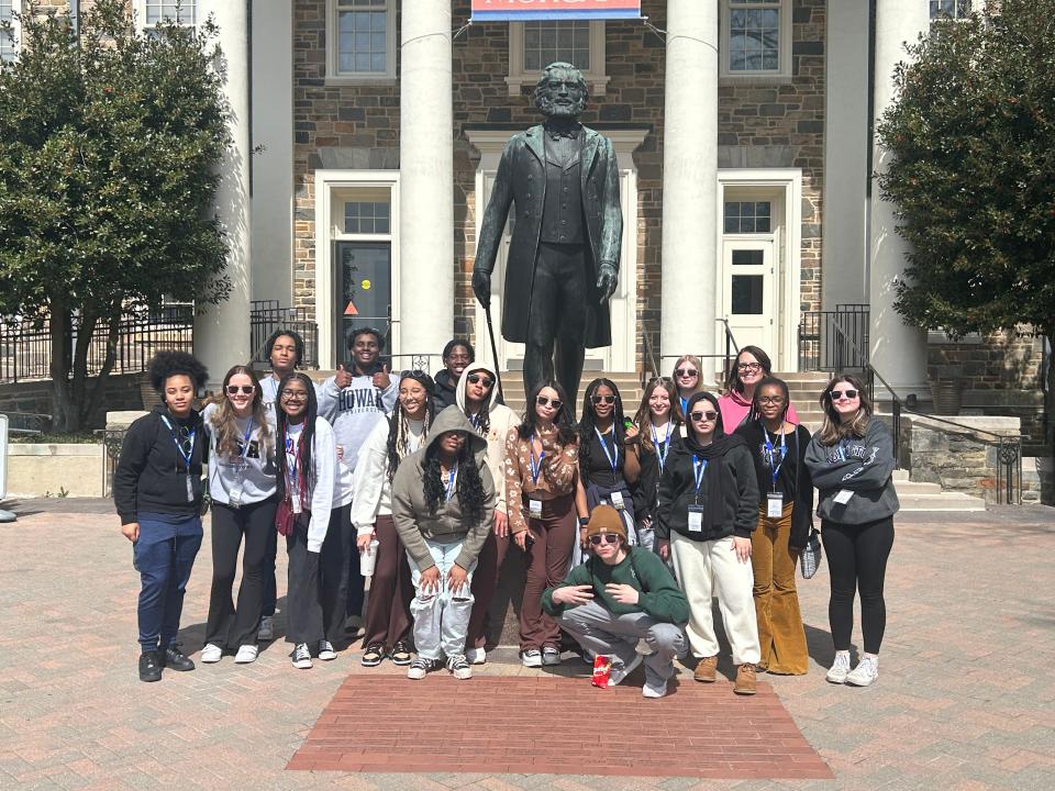 Rochester-area high school students stand in front of a statue of Frederick Douglass on the campus of Morgan State University in Baltimore, Maryland.