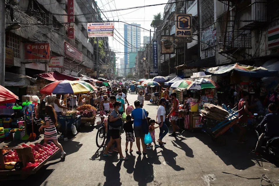 Shoppers walk past stalls at Divisoria Market in Manila, the Philippines, on Sunday, Dec. 5, 2021. The Philippines had loosened virus restrictions in recent weeks as Covid-19 infections declined but with the emergence of the virus variant however, Metro Manila will remain under Alert Level 2 to December 15 and the Southeast Asian nation has rolled back its reopening totourists. (Photo: Geric Cruz/Bloomberg via Getty Images)