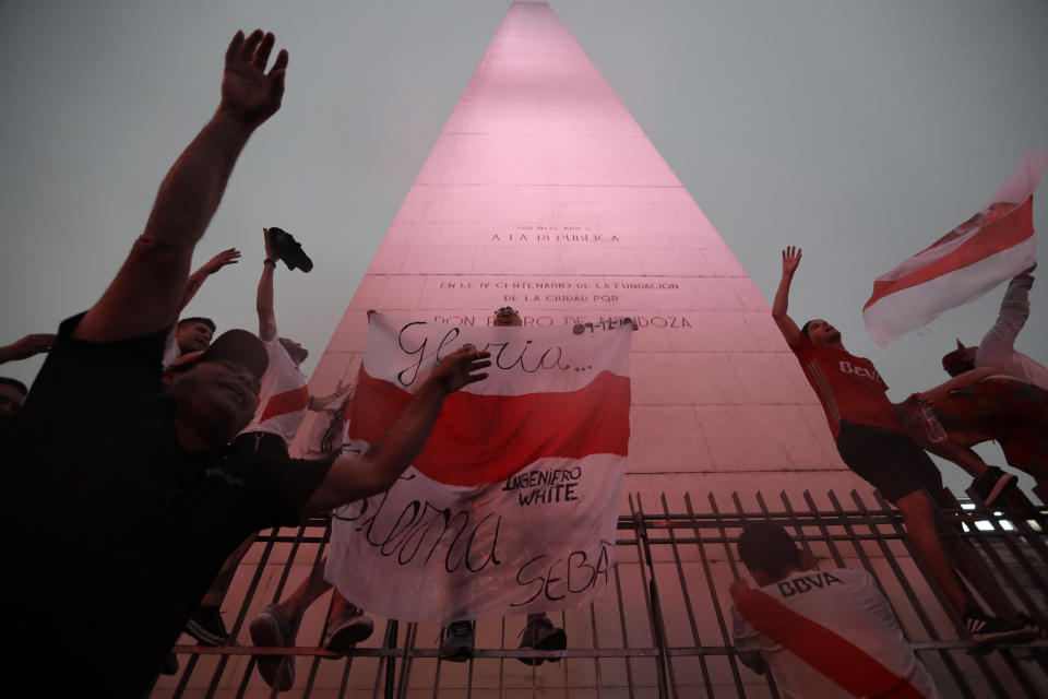 River Plate soccer fans celebrate defeating Boca Juniors 3-1 and clenching the Copa Libertadores championship title, at the Obelisk in Buenos Aires, Argentina, Sunday, Dec. 9, 2018. The South American decider was transferred from Buenos Aires to Madrid, Spain after River fans attacked Boca's bus on Nov. 10 ahead of the second leg. (AP Photo/Natacha Pisarenko)