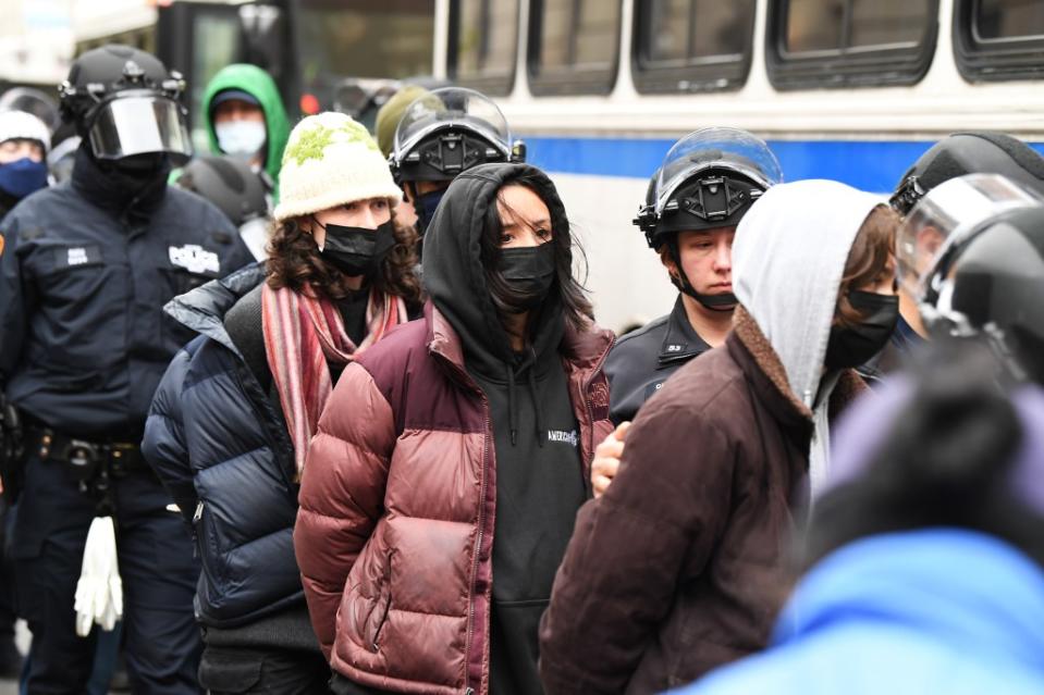 Pro-Palestinian protesters in handcuffs being led onto NYPD buses. Matthew McDermott