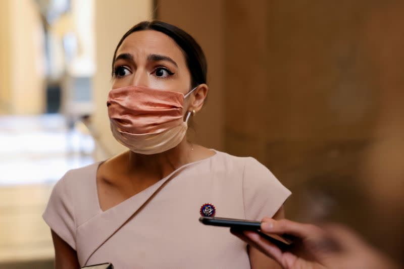 FILE PHOTO: U.S. Representative Alexandria Ocasio-Cortez reacts as she walks past reporters on Capitol Hill in Washington