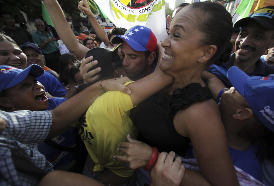 Venezuela's presidential candidate Henrique Capriles, center, kisses a supporter as he arrives for a campaign rally in Catia La Mar, Venezuela, Friday, Aug. 3, 2012. Venezuela's presidential election is scheduled for Oct. 7. (AP Photo/Fernando Llano)