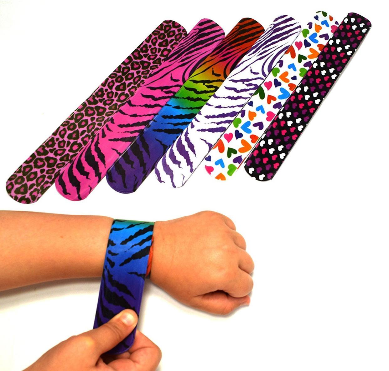 Assorted slap bracelets next to a wrist with a slap bracelet