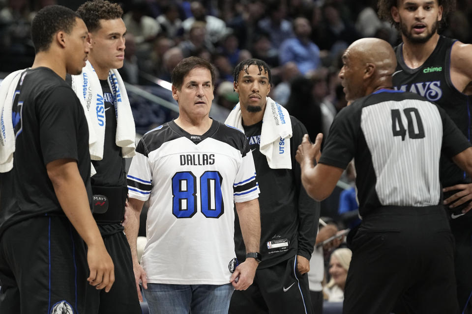 Referee Leon Wood (40) explains a call as Marc Cuban (80) looks on during the second half of an NBA basketball game between the Cleveland Cavaliers and Dallas Mavericks in Dallas, Wednesday, Dec. 27, 2023. (AP Photo/LM Otero)