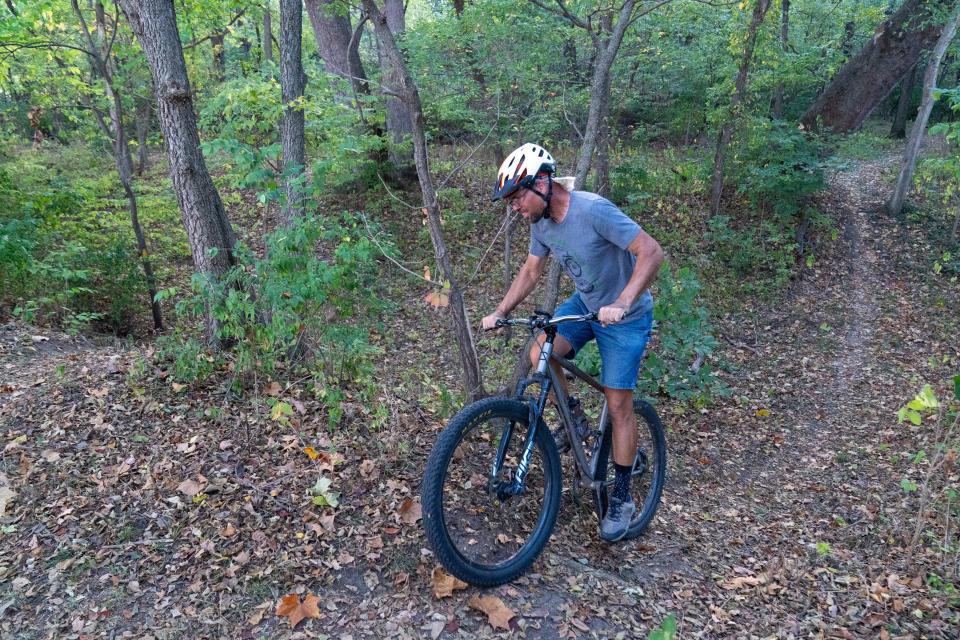 Riding what he and other local riders call "whoopty-doos" on the yellow trail at Dornwood Nature Trails, Andy Phillips keeps his momentum as he rides up and down the creek bed.