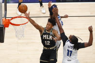 Atlanta Hawks forward De'Andre Hunter (12) goes up for a shot as center Naz Reid (11) and Minnesota Timberwolves forward Jarred Vanderbilt (8) defend in the first half of an NBA basketball game on Monday, Jan. 18, 2021, in Atlanta. (AP Photo/Todd Kirkland)