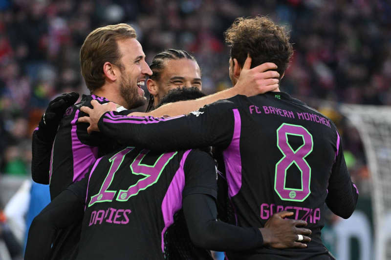 (L-R) Munich's Harry Kane celebrates with Alphonso Davies, Leroy Sane and Leon Goretzka after his third goal of the game during the German Bundesliga soccer match between FC Augsburg and Bayern Munich at the WWK-Arena. Sven Hoppe/dpa